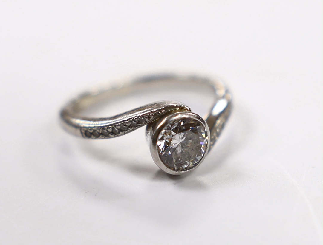 A modern platinum and collet set single stone diamond ring with diamond chip set crossover shoulders, size K, gross weight 5.5 grams